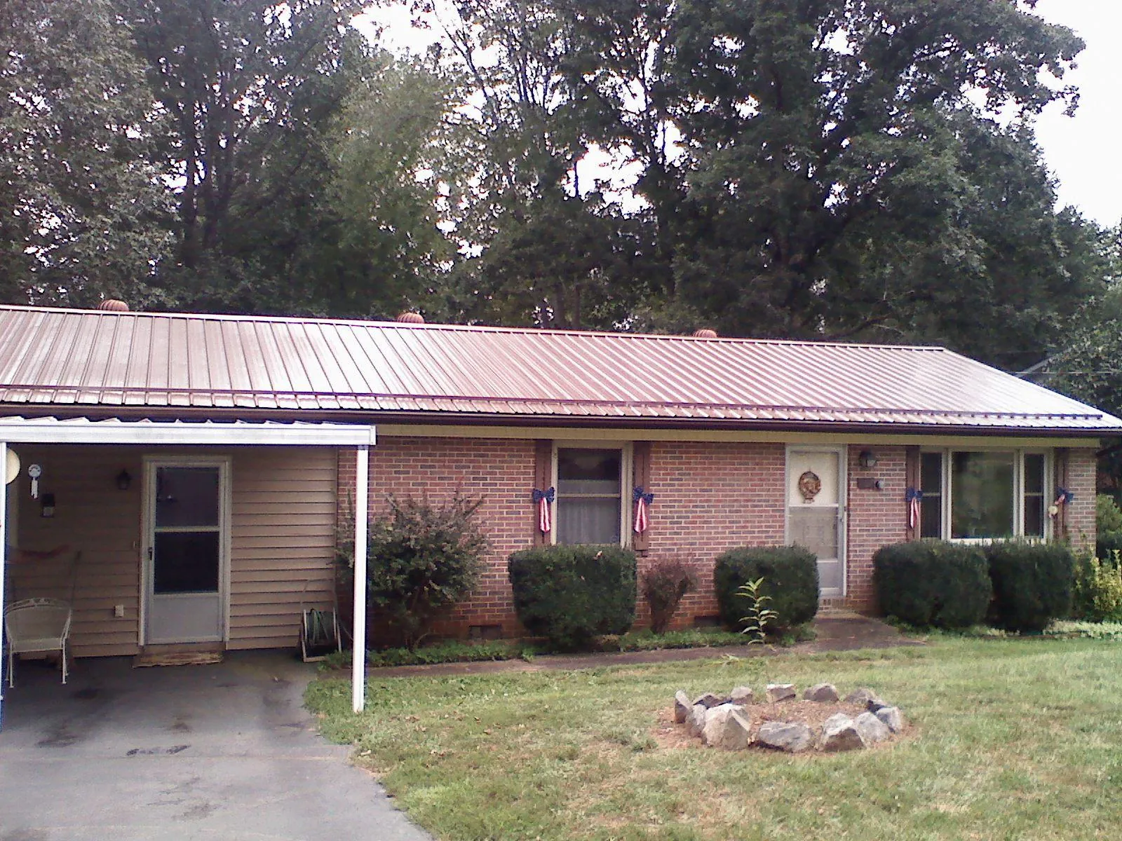 Bronze metal roof and carport on a brick ranch home — Roof Repair work by our crew in Clark Fork